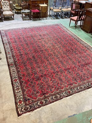 Lot 426 - Large Persian Bendarian wool carpet red ground...