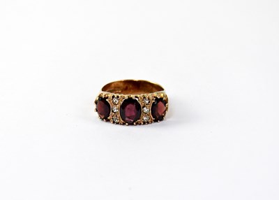 Lot 1071 - A 9ct gold dress ring set with three garnets...