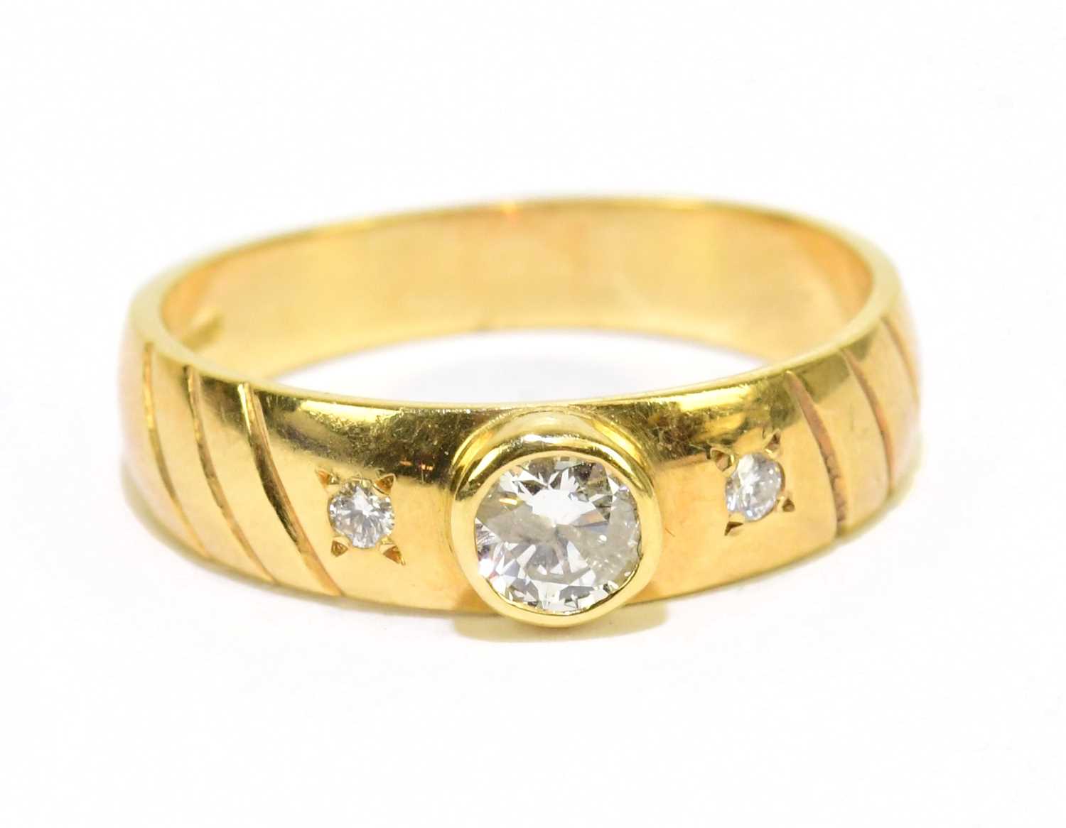 Lot 905 - An 18ct yellow gold three stone dress ring,