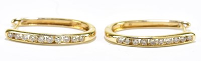 Lot 1278 - A pair of yellow metal diamond set hoop...