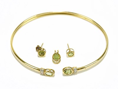 Lot 1297 - A yellow metal peridot set bangle with...