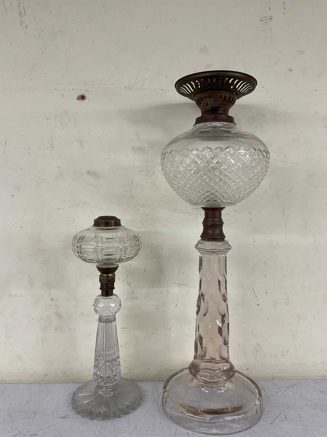 Lot 84 - Two cut glass oil lamps, height of tallest 52cm.