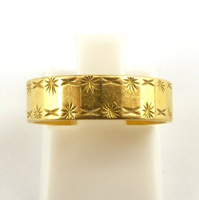 Lot 882 - A 22ct gold band ring with textured pattern,...