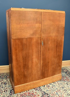 Lot 2406 - A 1930's oak compactum wardrobe, the pair of...