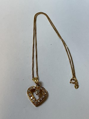 Lot 300 - A yellow metal and diamond heart shaped...