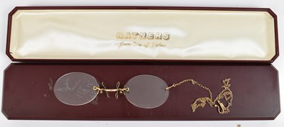 Lot 668 - A pair of reading glasses with yellow metal...