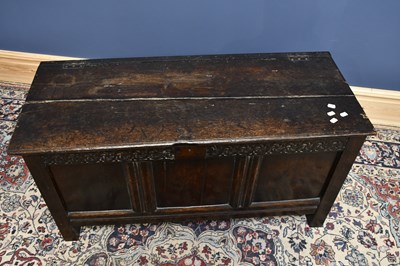 Lot 1663 - An 18th century oak coffer, with carved...