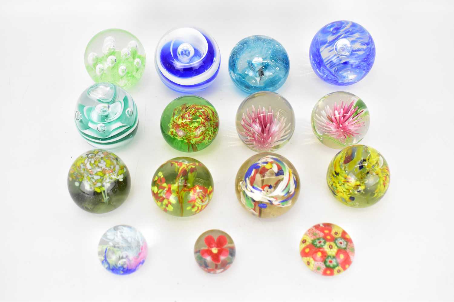 Lot 317 - Fifteen small floral inset glass paperweights...