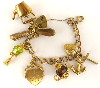 Lot 1051 - A 9ct gold charm bracelet with eight charms,...