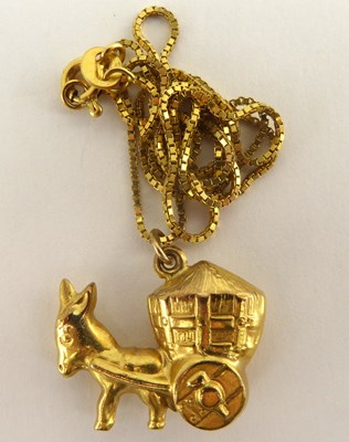 Lot 1106 - A 9ct gold donkey and cart pendant on a 9ct...