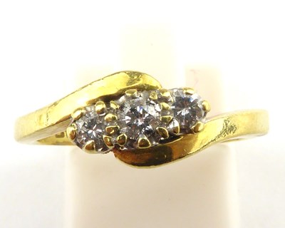 Lot 979 - An 18ct gold three small crossover diamond...
