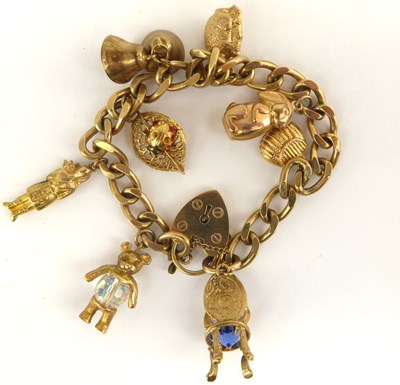 Lot 1052 - A 9ct gold curb link charm bracelet set with...