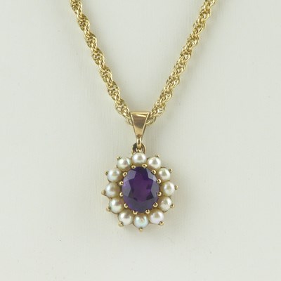 Lot 1096 - An amethyst and seed pearl cluster pendant in...