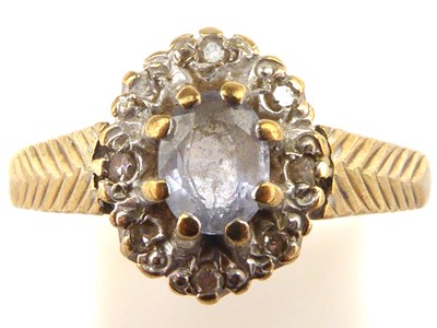 Lot 991 - A 9ct gold dress ring with central blue stone...