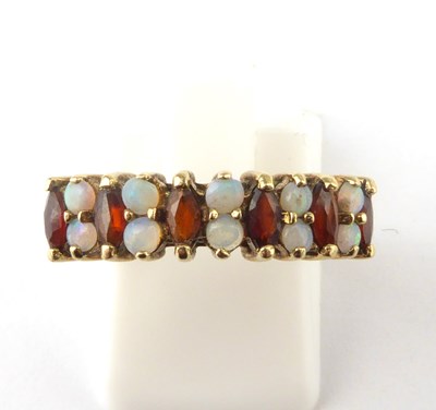 Lot 929 - A 9ct gold opal and garnet half eternity ring...