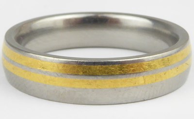 Lot 1011 - FENIOM; a titanium and yellow gold inlaid ring,...