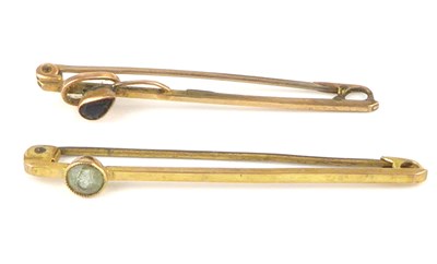 Lot 1066 - Two 9ct gold bar brooches, each set with a...