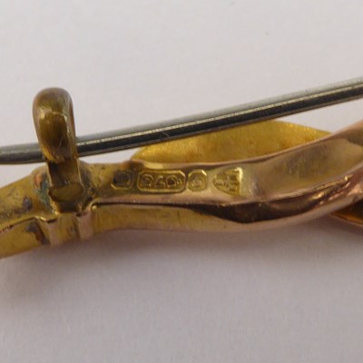 Lot 1065 - A 9ct gold bar brooch with three tiny diamonds...