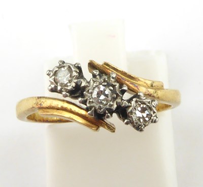 Lot 915 - An 18ct gold three-stone diamond crossover...