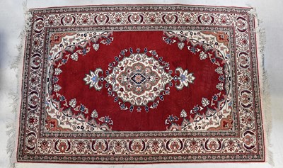 Lot 101 - A red ground carpet with central medallion...