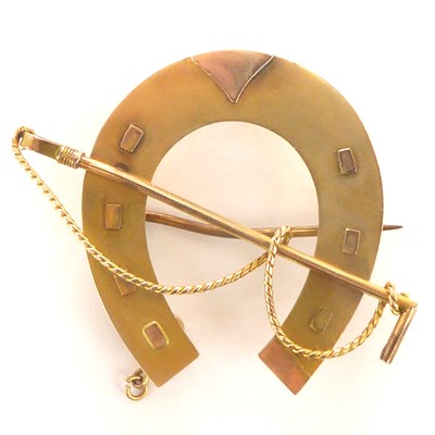 Lot 1064 - A 9ct gold horseshoe and riding crop brooch, 3....