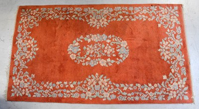 Lot 91 - A terracotta ground floral rug, length 121cm.