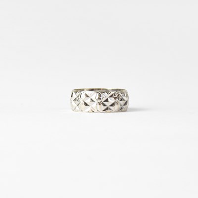 Lot 894 - An 18ct white gold and facet cut wedding band,...