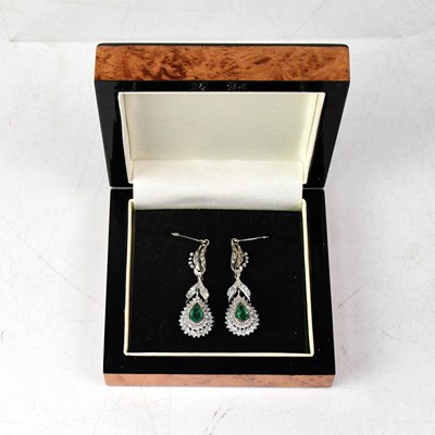 Lot 1090 - A pair of white metal diamond and emerald drop...