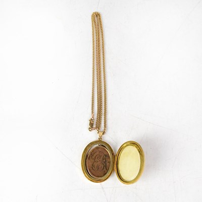 Lot 1111 - A 9ct yellow gold floral engraved oval locket...
