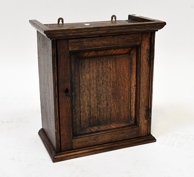 Lot 72 - A George III oak spice cupboard, the fielded...