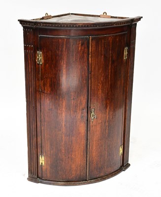 Lot 28 - A George III oak bow-fronted hanging corner...