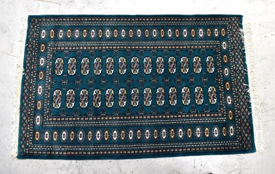 Lot 92 - A red ground Bokhara design rug and a green...