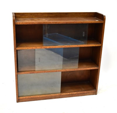 Lot 24 - A mid-20th century oak three-section bookcase...