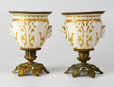 Lot 238 - A pair of gilded vases with applied winged...