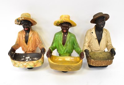 Lot 137 - Three figural busts of men holding baskets in...