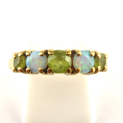 Lot 993 - A 9ct gold opal and green stone ring, with...
