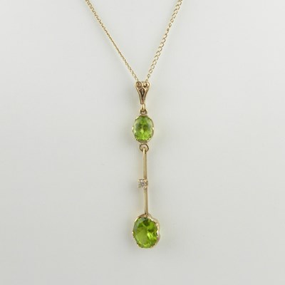 Lot 1103 - A 9ct gold bar drop pendant with a claw set...