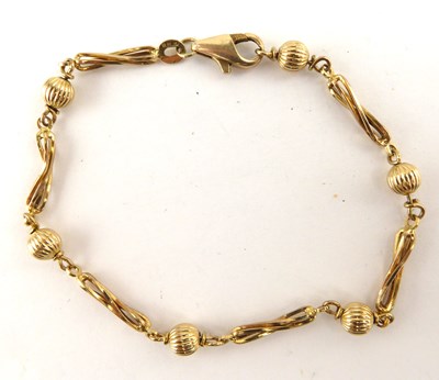 Lot 1029 - A 9ct gold ball and twist bar bracelet, with...