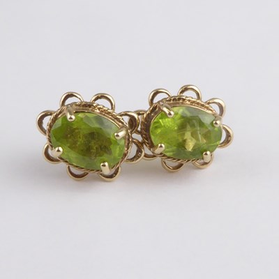 Lot 1176 - A pair of 9ct gold claw set oval cut peridot...