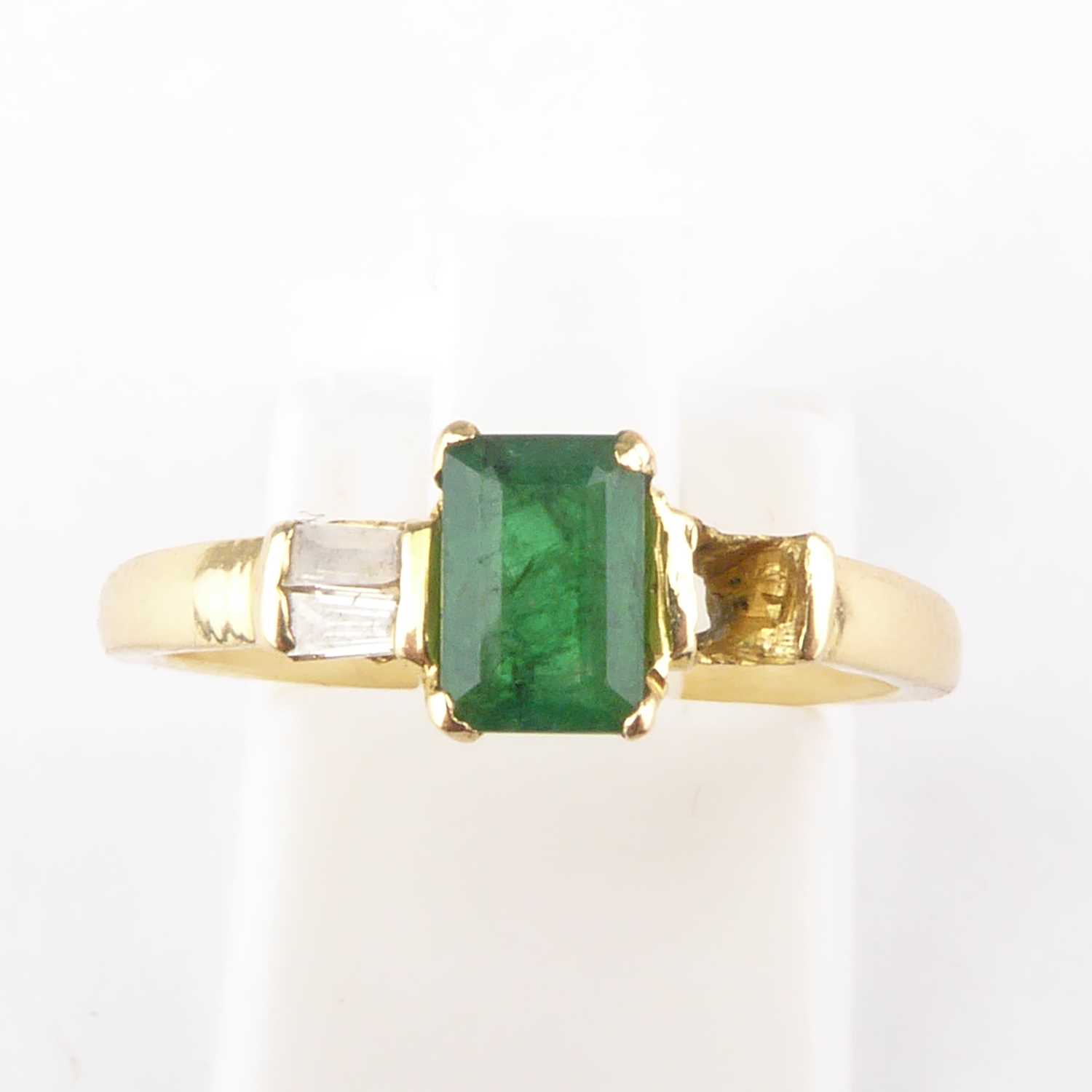 Lot 973 - A gold diamond and emerald ring, the emerald