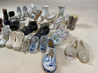 Lot 188 - A collection of ornamental ceramic shoes, many...