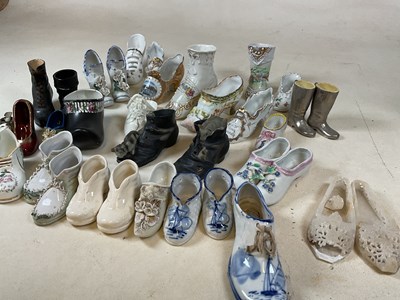 Lot 188 - A collection of ornamental ceramic shoes, many...