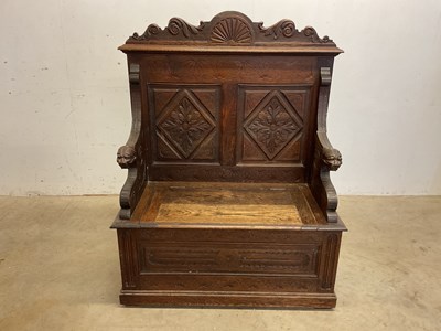 Lot 557 - A c.1900 carved oak hall bench with mask...