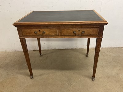 Lot 601 - An Edwardian oak two drawer desk/side table...