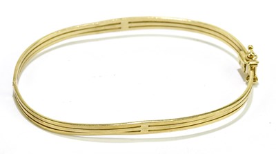 Lot 188 - A 9ct yellow gold bangle with twin safety...