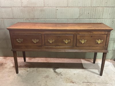 Lot 529 - A late George III oak three drawer dresser...