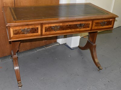 Lot 47 - A reproduction writing table, the leather...