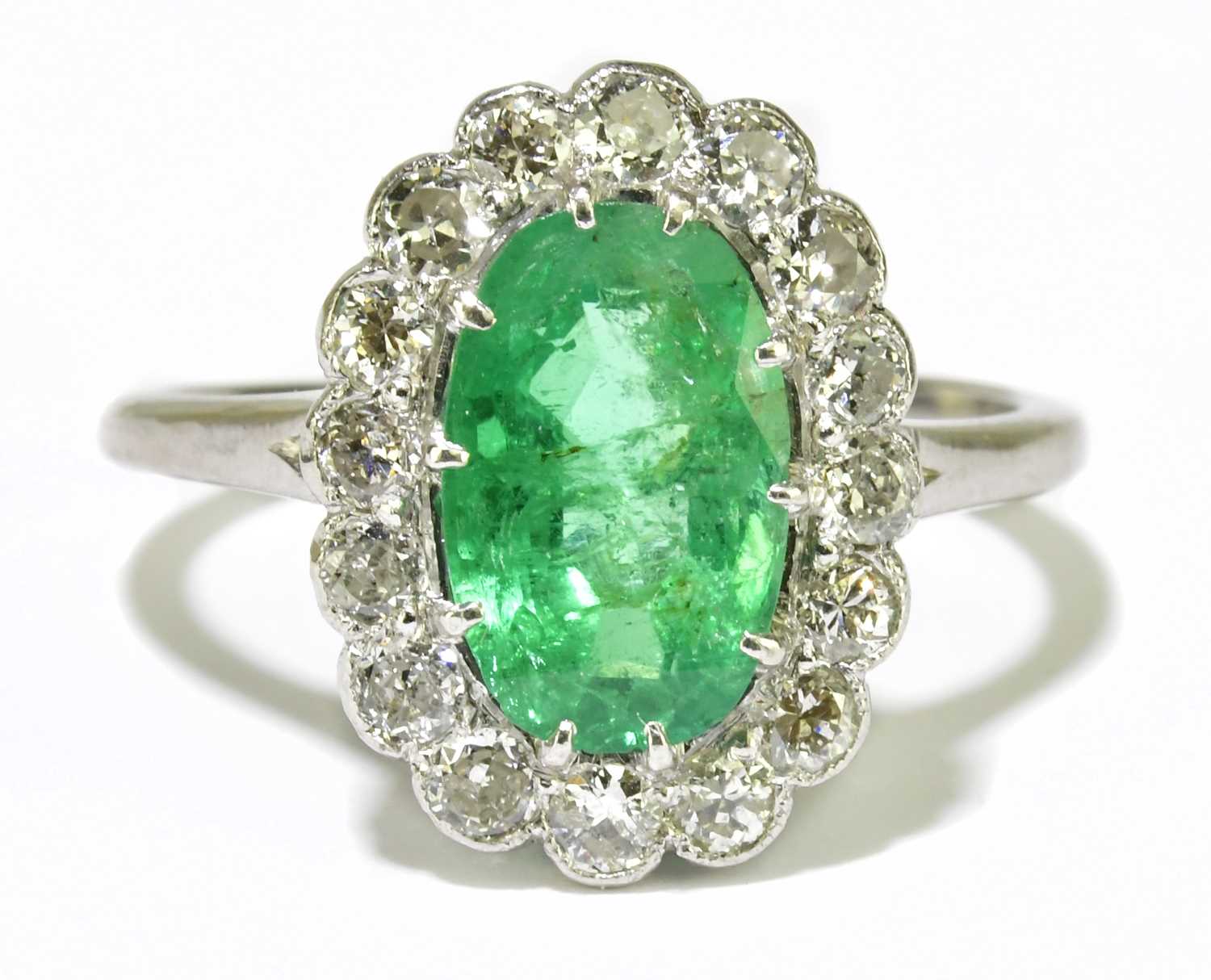 Lot 25 - A platinum diamond and emerald cluster ring,