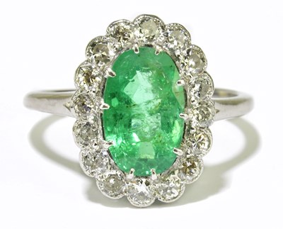Lot 25 - A platinum diamond and emerald cluster ring,...