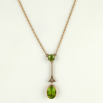 Lot 887 - An Edwardian-style bezel set cut green stone...